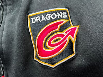 Embroidered black and red Dragons logo on coat